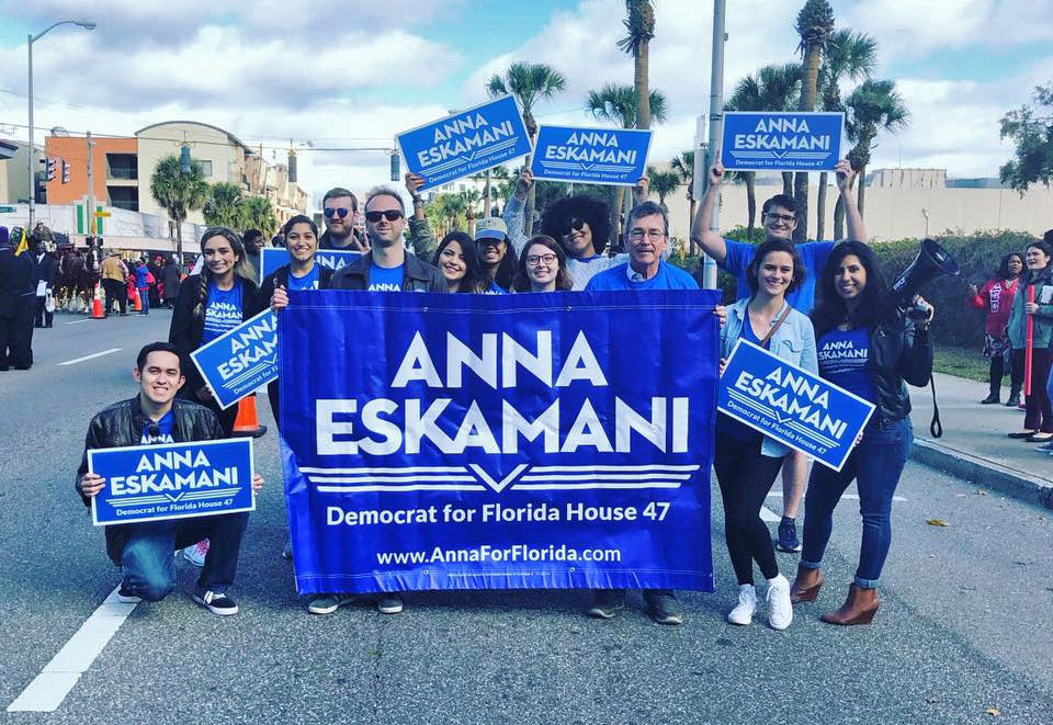 Anna Eskamani campaign team posing around a campaign large banner